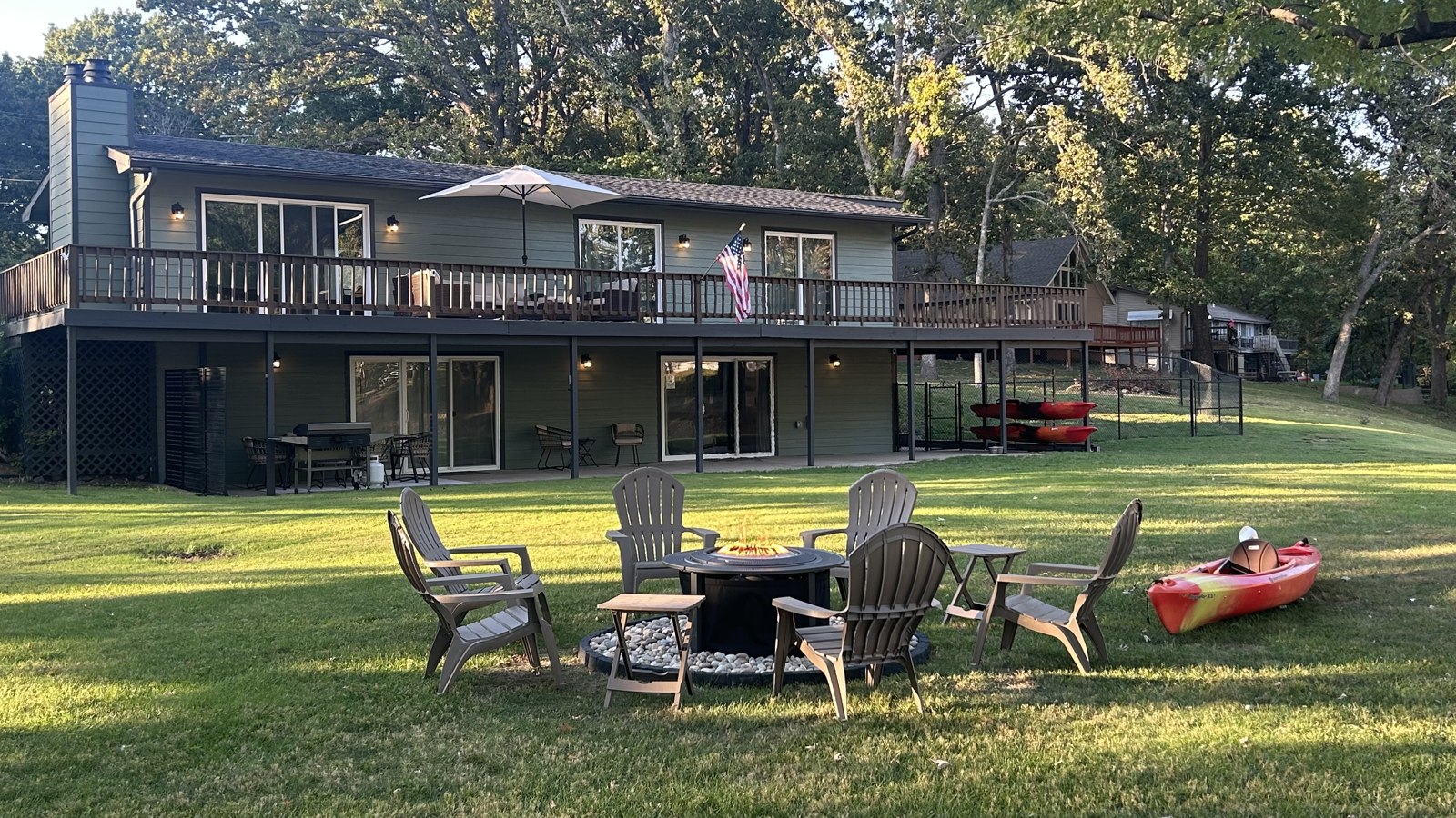 Lake-facing home with outdoor seating and a kayak