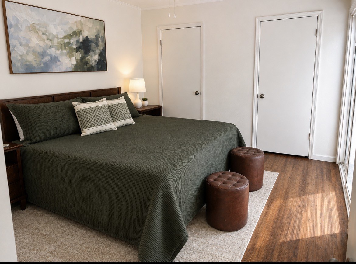Bedroom with green bedding and warm wood floors