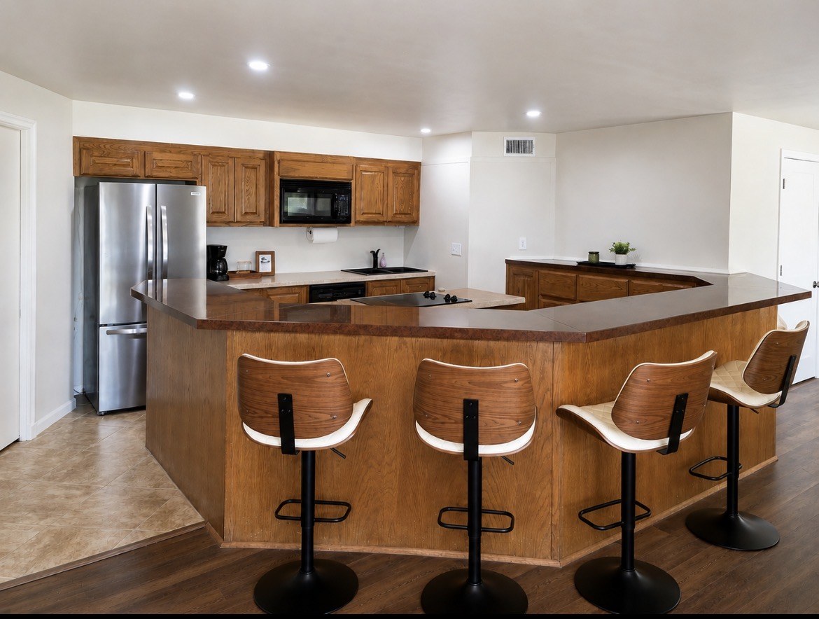 Downstairs kitchen with wood cabinets and seating at the counter