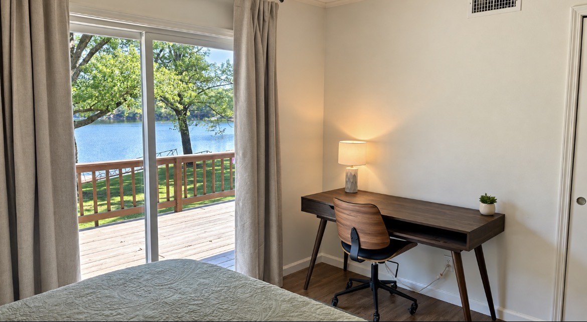Bedroom desk beside sliding doors overlooking the deck and lake