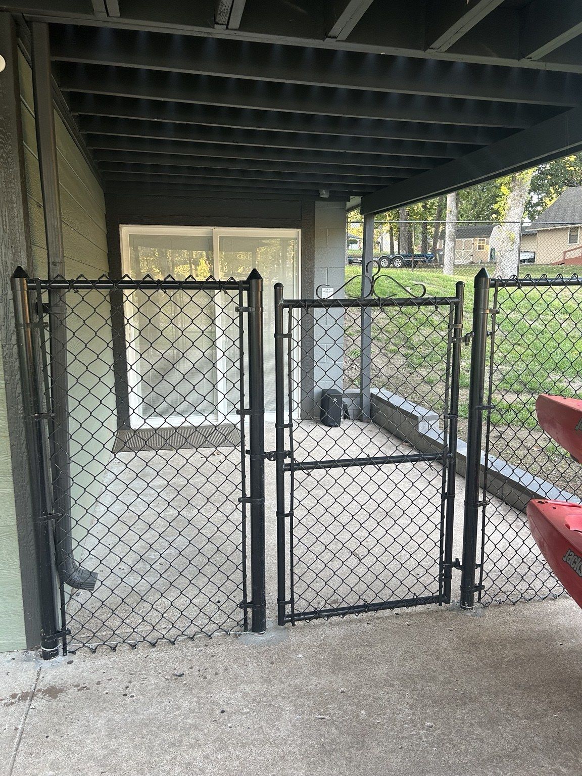 Covered fenced patio beside the downstairs entrance