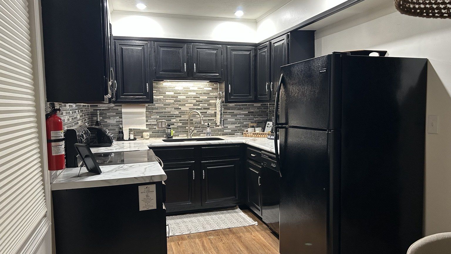 Upstairs kitchen with dark cabinets and bright countertops